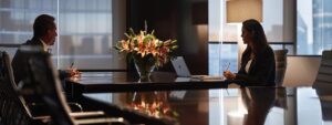 a modern law office filled with sleek furniture and ambient lighting, featuring an attentive lawyer engaged in a focused consultation with a concerned client at a polished conference table.